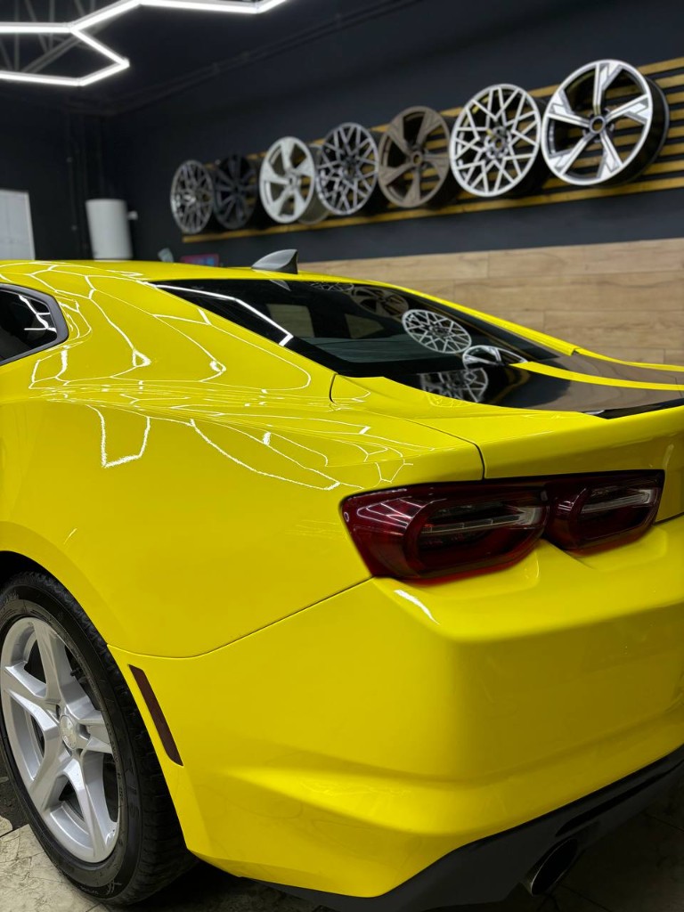 Chevrolet Camaro в глянцевом жёлтом SKINGARD — задний 3/4 в студии