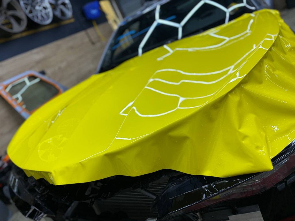 Оклейка капота Camaro жёлтой глянцевой плёнкой SKINGARD